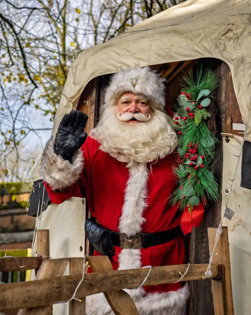 Santa with wreath outside yurt