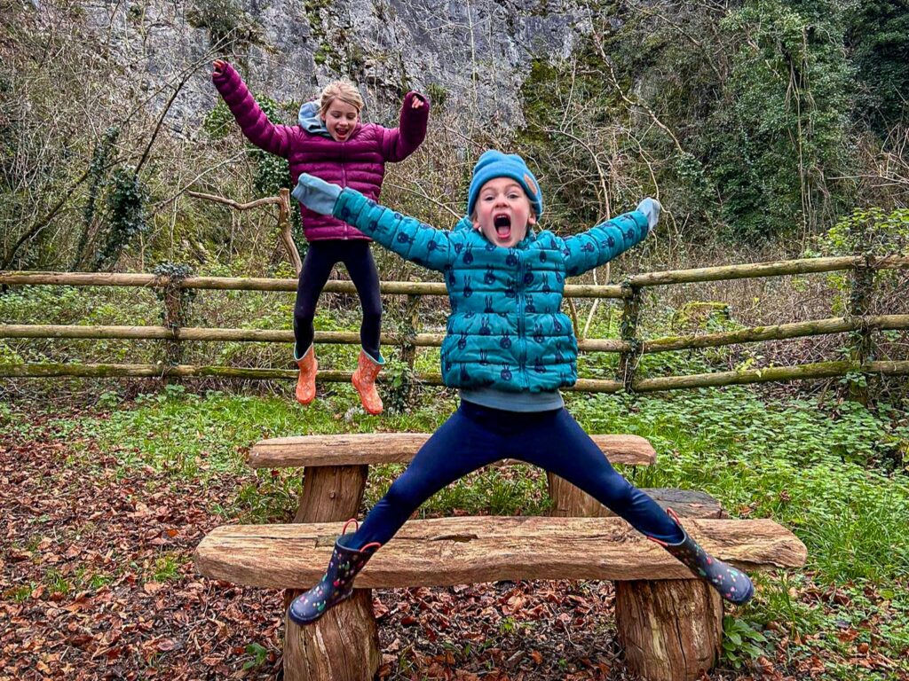 Children jumping and playing at Paignton Zoo's Nature Trail in Clennon Gorge wildlife reserve